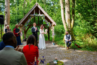 a couple smiling and applauding their musician in the ceremony area at the woods at oakley