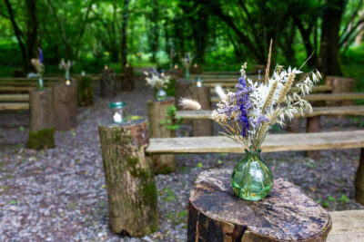 flowers in jars at the end of benches in the ceremony area at the woods at oakley