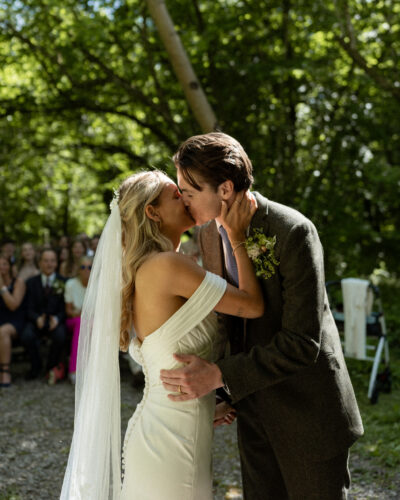 a bride and groom kiss in a woodland 