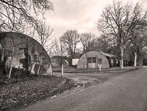 A black and white photo of old World War 2 nissen huts