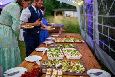Guests at a buffet table in a marquee