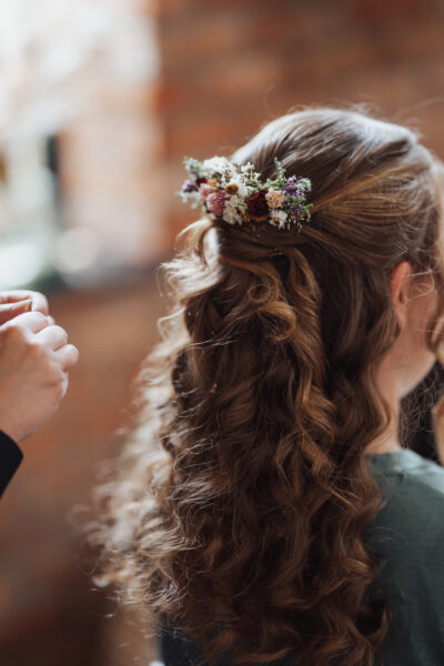 a bride's hair from the back with long curls and flowers